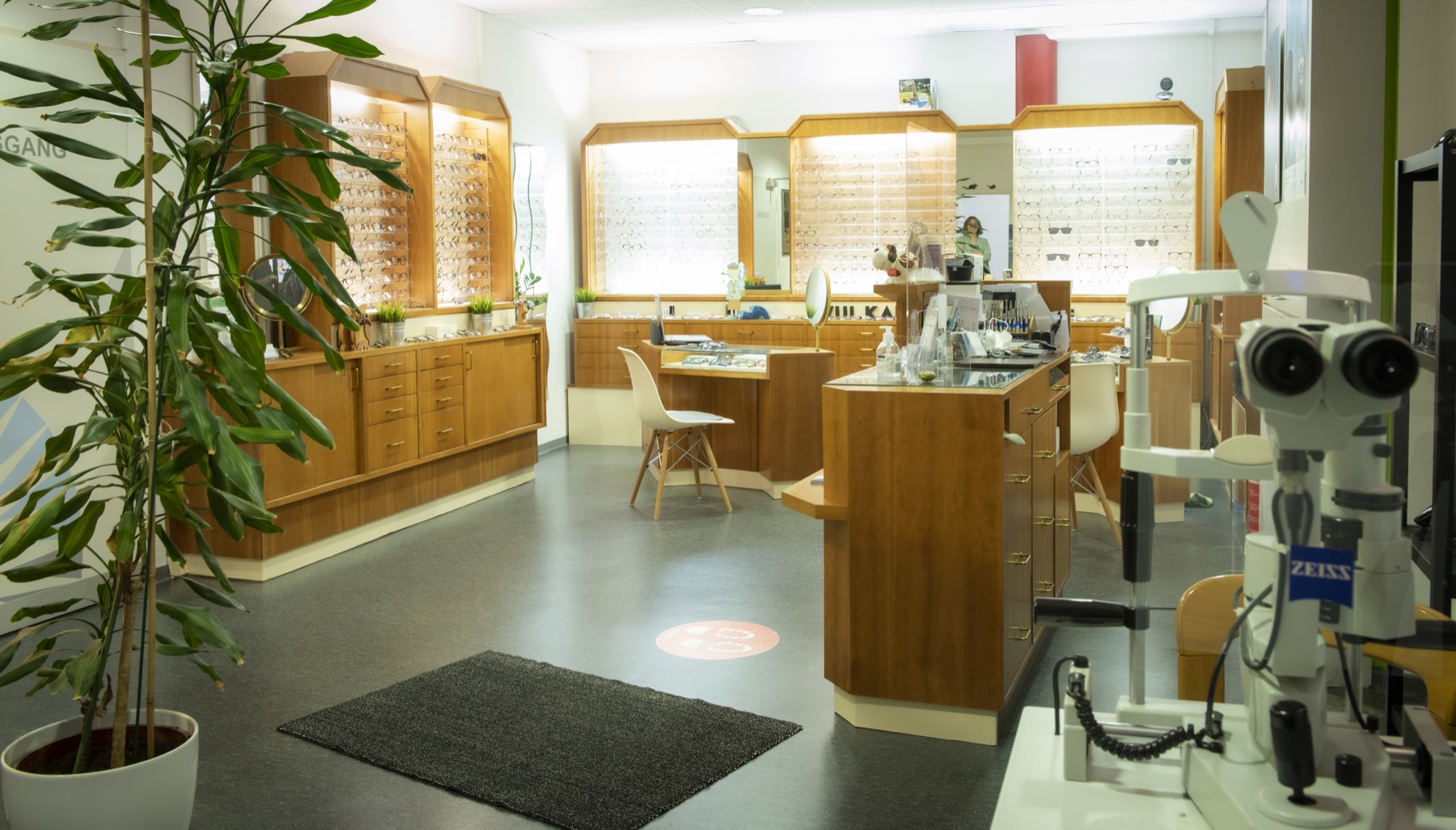 Innenraum von Augenoptik Kleine mit Brillenwänden und Messgerät.